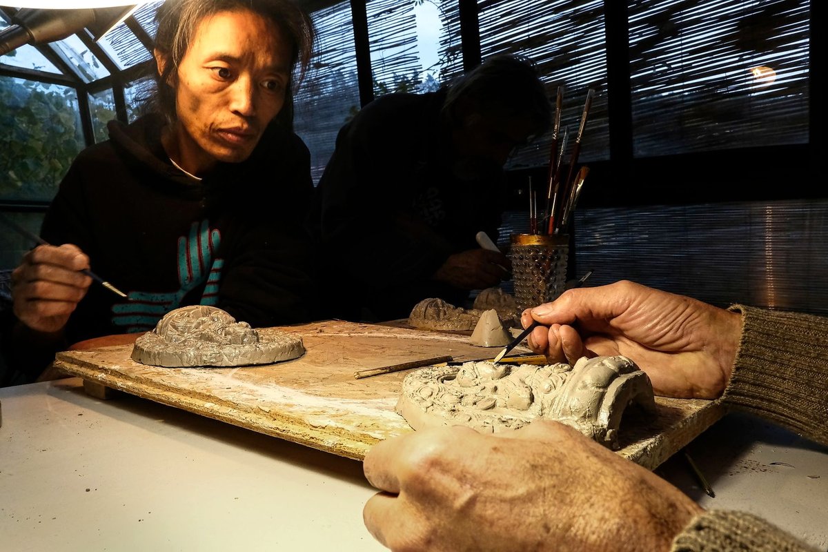 Chungpo Tsering při práci na hliněné soše v ateliéru ve Všenorech